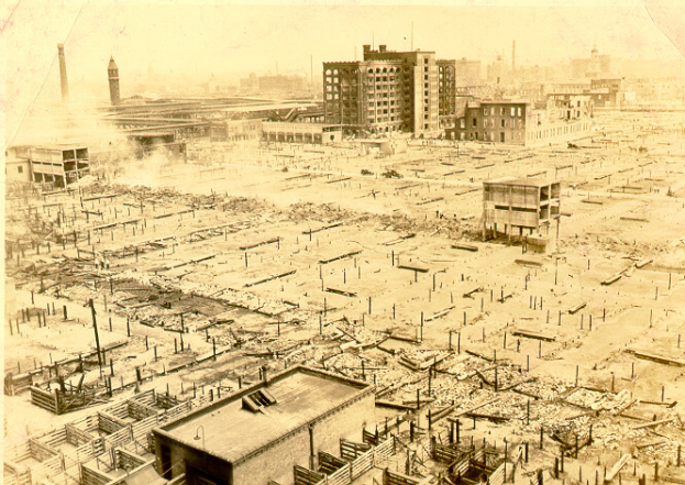 Ein altes Schwarz-Weiß-Foto einer Stadtlandschaft mit zahlreichen Gebäuden, Mästen und einem Turm im Hintergrund, mit dem Text "New York City's Second World War" unten.