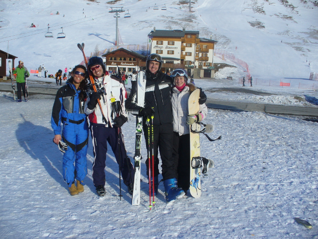 Vier Personen posieren mit Skating-Pads und Werkzeugen vor einer schneebedeckten Bergkulisse.