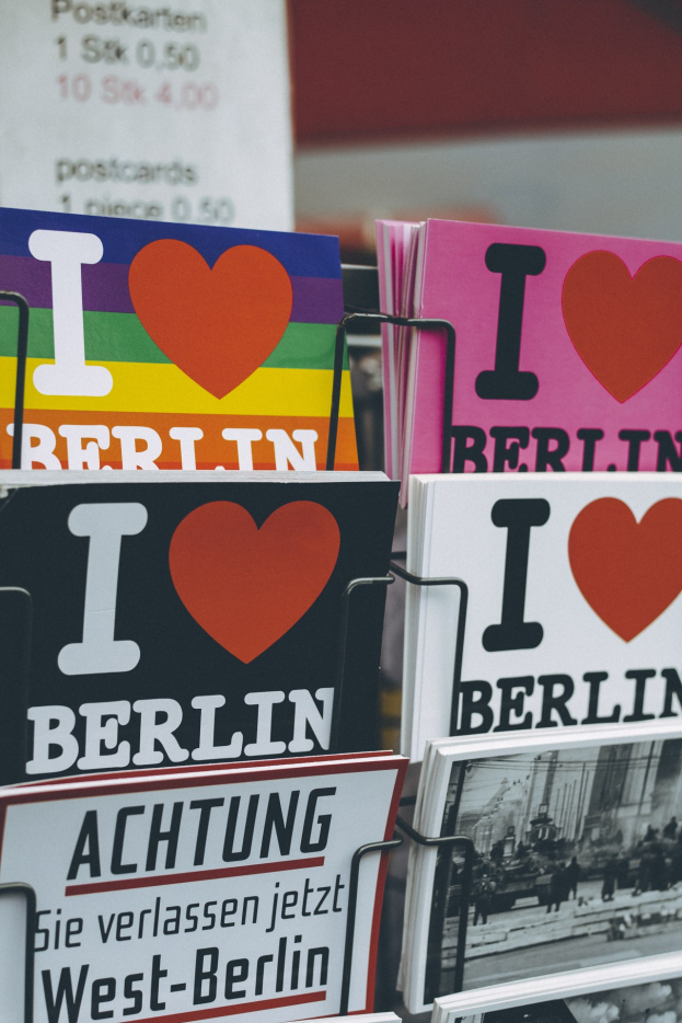 Ein Gestell mit Büchern und Postern mit der Aufschrift "Ich liebe Berlin", vor einem leicht unscharfen, träumerischen Hintergrund.