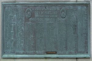 Plakette an einer Gebäudewand mit der Aufschrift "Denkmal für die Stadt Portland" in fetter schwarzer Schrift mit einem dekorativen Rahmen.