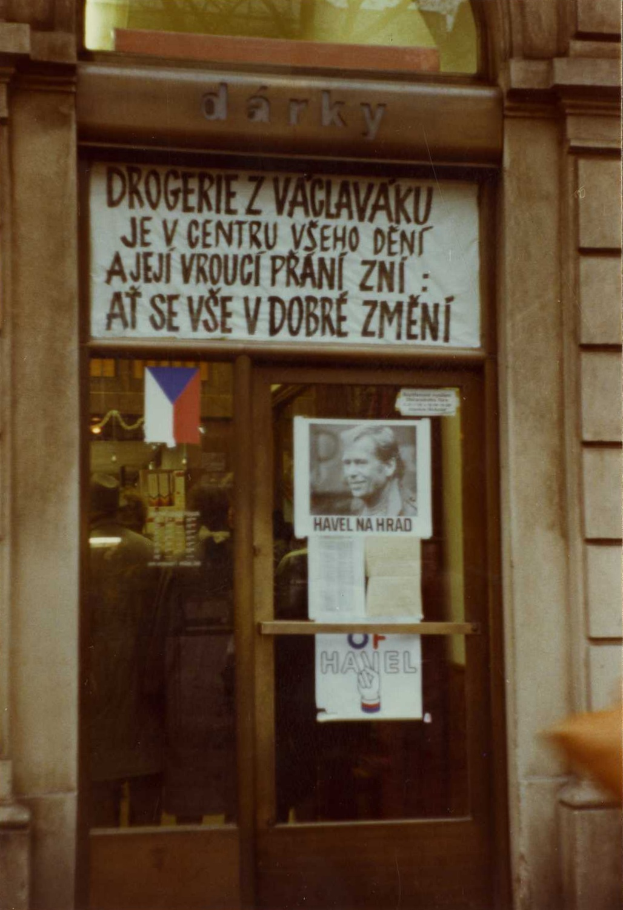 Ein altes Foto einer Glastör mit einem Schild, einem Plakat einer Person und einigen aufgeklebten Papieren.