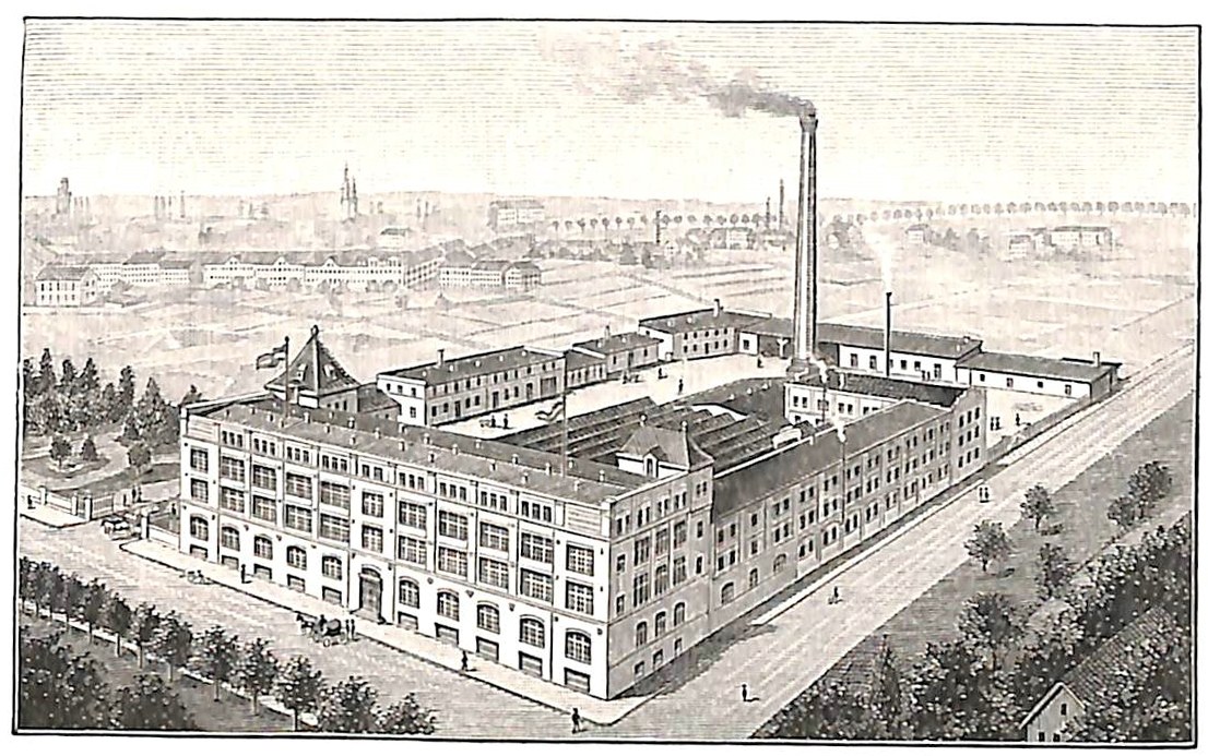 Altes Industriegebäude mit einem großen zentralen Gebäude umgeben von Bäumen und Text unten.
