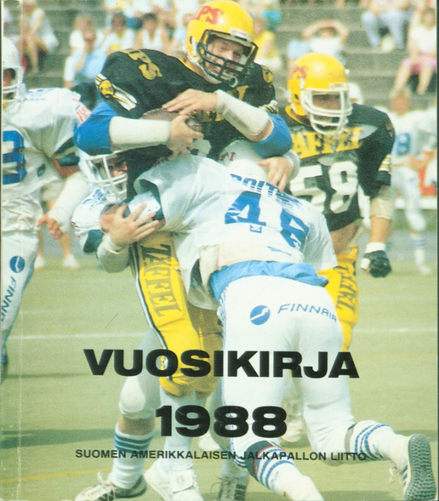 Eine Gruppe von Menschen in Sportbekleidung und Helmen, die Fußball auf einem Feld spielen, mit einigen Personen, die im Hintergrund auf einer Treppe sitzen; unten steht ein Text, der 'Vuosikirja 1988 - Suomen Amerikkaisen Jalkapallon Litto' lautet.