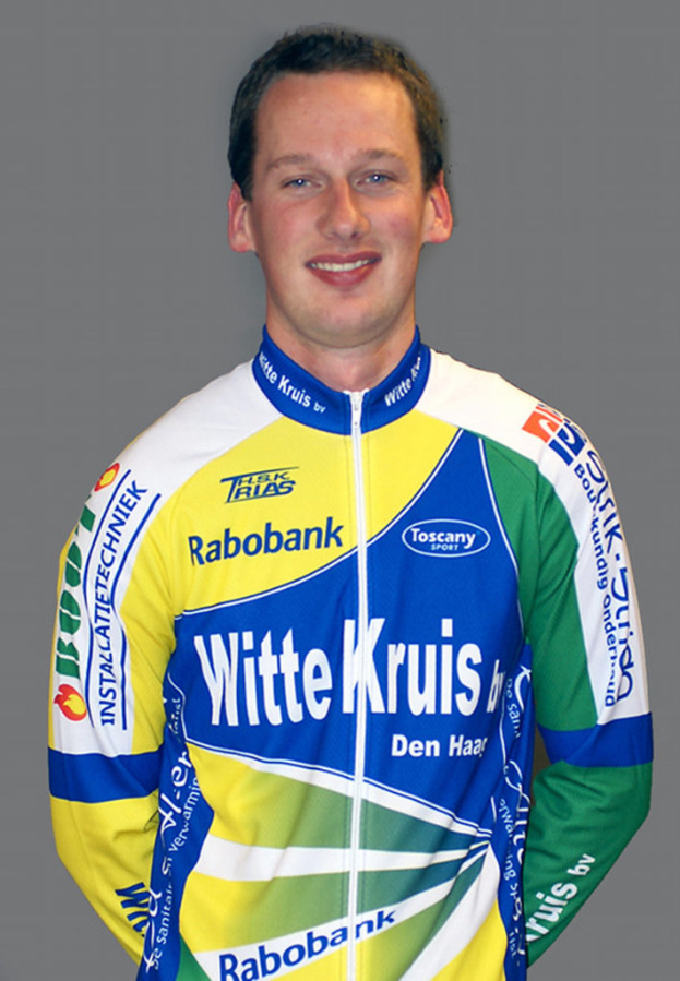 Ein Sportler posiert für ein Foto, trägt ein Hemd mit verschiedenen Sponsorunternehmen.