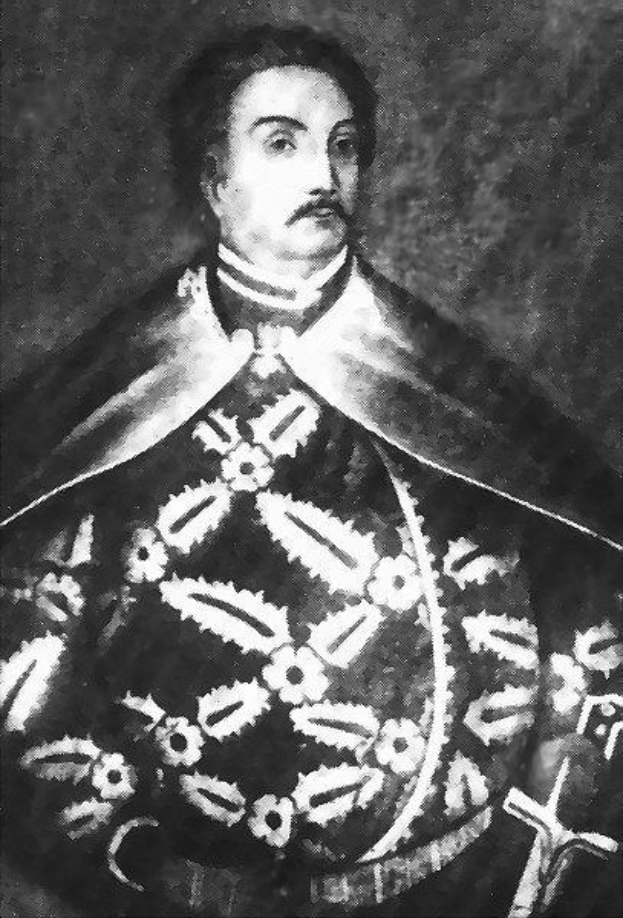 Schwarzes und weißes Foto von Papst Johannes Paul II. in Priesterrobe, der eine schwarze Robe mit weißem Kragen und Manschetten trägt und die Hände verschränkt, mit ernster Miene und direktem Blick.