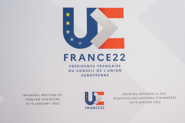 Plakat für die 'Frankreich 22 - Informelle Tagung der Außenminister' mit dem Logo der Europäischen Union, das einen blauen Kreis mit einem weißen Stern und schwarzen Text in der Mitte zeigt.