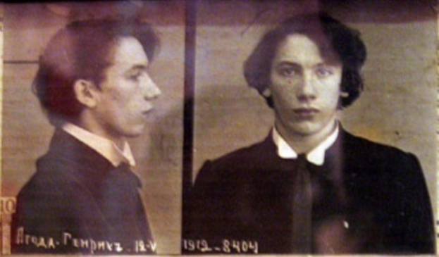 Ein Bild eines Mannes in einem schwarzen Anzug, weißem Hemd und schwarzer Krawatte mit ernstem Gesichtsausdruck, gefächteten Händen und zurückgekämmten Haaren, begleitet von zwei kleineren Fotos von ihm und fett gedrucktem Text über seine Verbrechen.