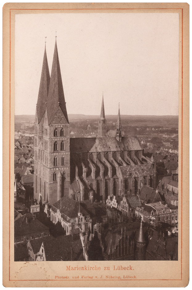 Ein altes Foto einer Stadt mit einer Kirche in der Mitte, umgeben von anderen Gebäuden, und Text unten auf dem Bild.