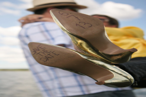 Frauenabsätze mit Datumsangaben darauf, mit einer Person, die eine Frau an den Beinen hält.