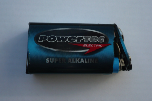 Ein blaues Powertec Super Alkaline-Batterie auf einer weißen Oberfläche, beschriftet mit "Powertec" in fetter Schrift.