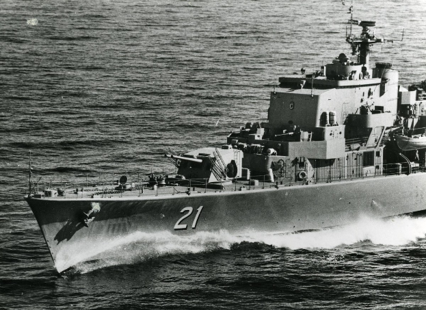 Schwarzes und weißes Foto eines großen gelenkten Marschflugkörpers mit einer sichtbaren Identifikationsnummer, der auf dem Wasser fährt.