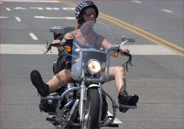 Frau mit schwarzem Helm fährt Fahrrad auf Straße