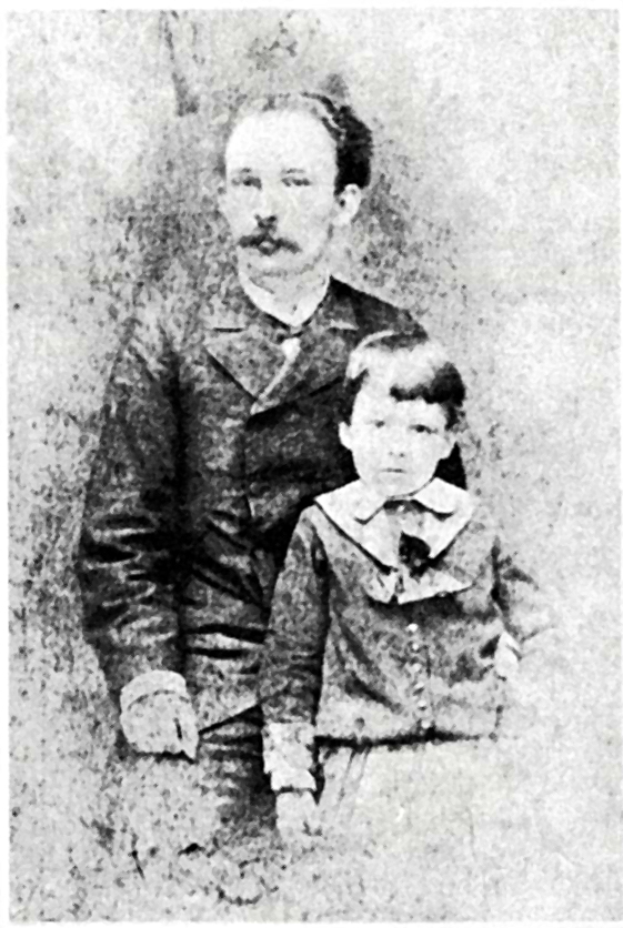 Ein altes Schwarz-Weiß-Foto eines Mannes mit ernster Miene und einem Kind, das neugierig zu ihm hochschaut.