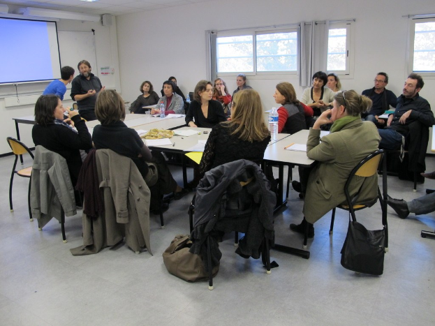 Eine Gruppe von Menschen, die sich unterhält, wobei zwei andere separat stehen und sprechen.