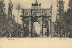 Schwarzes und weißes Foto eines Münchner Triumphbogens mit Skulpturen, Bäumen, Pfählen, Gebäuden und Himmel mit Text unten.