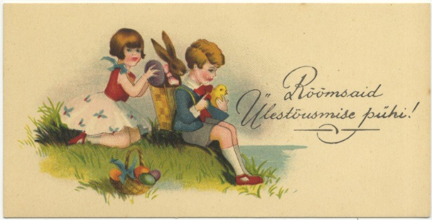 Schwarz-weiß-Postkarte mit zwei Kindern auf dem Gras sitzend, eines hält einen Korb mit Ostereiern und das andere ein Spielzeug, im Hintergrund ein Plakat mit Text.