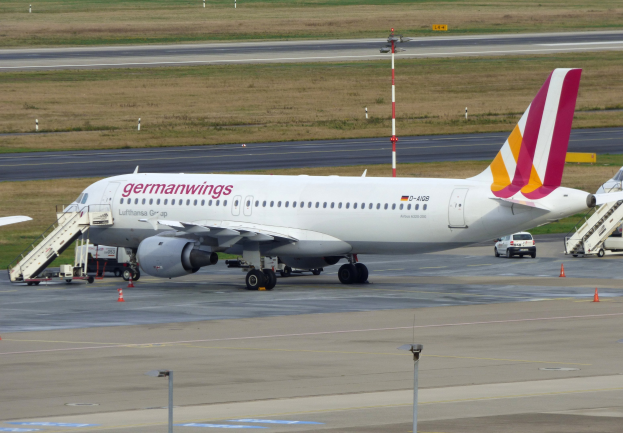 Germanwings Airbus A320-200 am Frankfurt Airport mit Bodenfahrzeugen, Verkehrskegeln, Pfosten und Gras im Hintergrund.