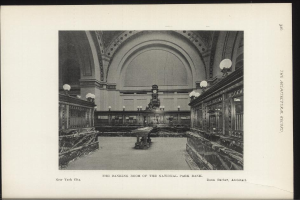 Schwarzes und weißes Foto der Bankhalle des National Park Bank in New York City, das Tische, Beleuchtung, eine Wanduhr und Text am unteren Rand zeigt.
