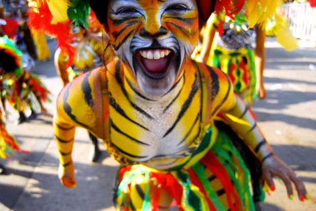 Eine Gruppe von Menschen in bunten Kostümen und Schminke, mit einer Frau in einem Tigerkostüm, auf einem Karneval.